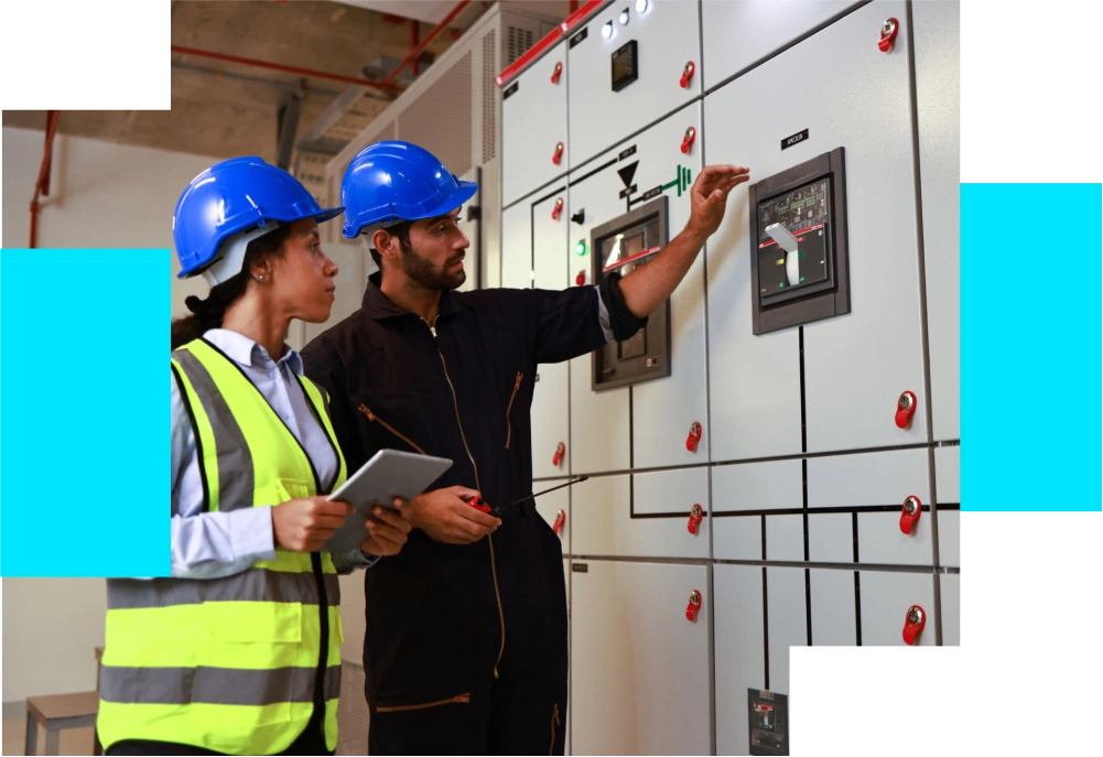 Two workers inspecting electrical control panel.